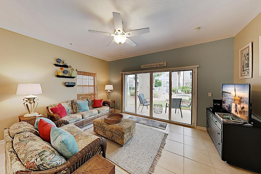 a living room with a couch and a flat screen tv at Villas Ocean Gate II Condo Unit 105 in Saint Augustine