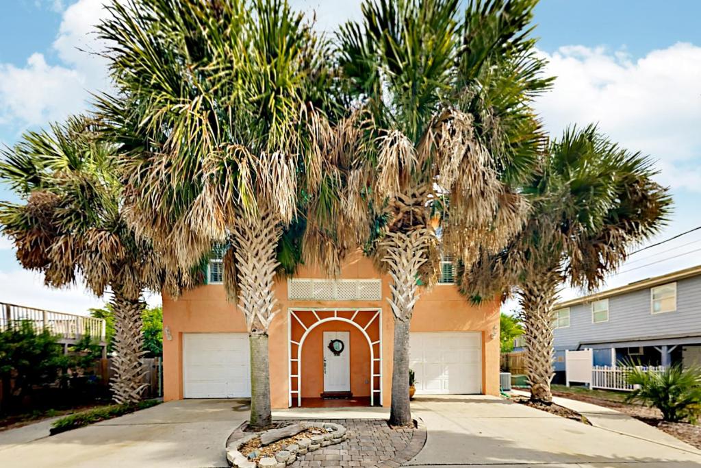 a house with palm trees in front of a driveway at Poseidons Cabana in St. Augustine