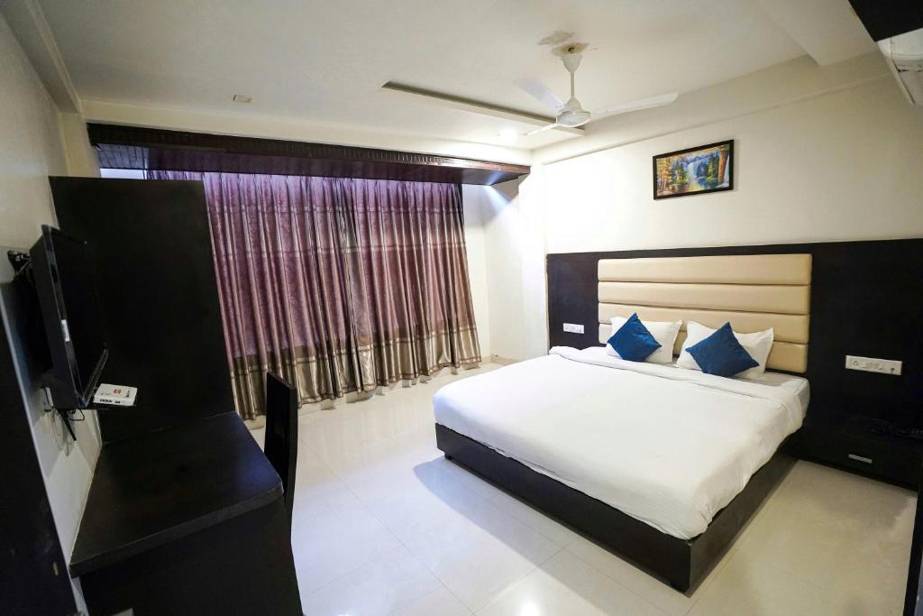 a bedroom with a bed and a television in it at Hotel Suryansh in Udaipur