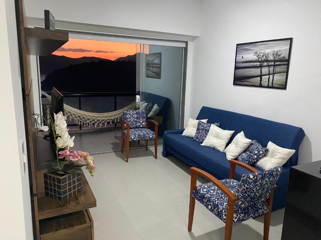 un soggiorno con divano blu e amaca di APARTAMENTO PORTO REAL RESORT VISTA ESPETACULAR a Mangaratiba