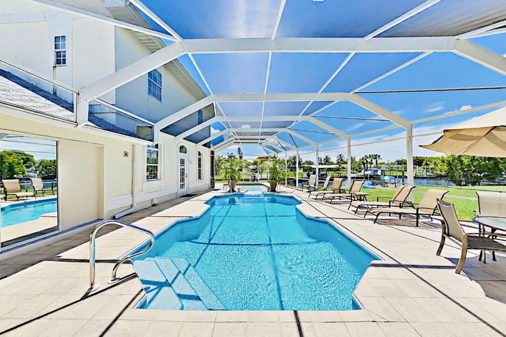 an indoor pool with chairs and an umbrella at Villa Euphoria in Cape Coral