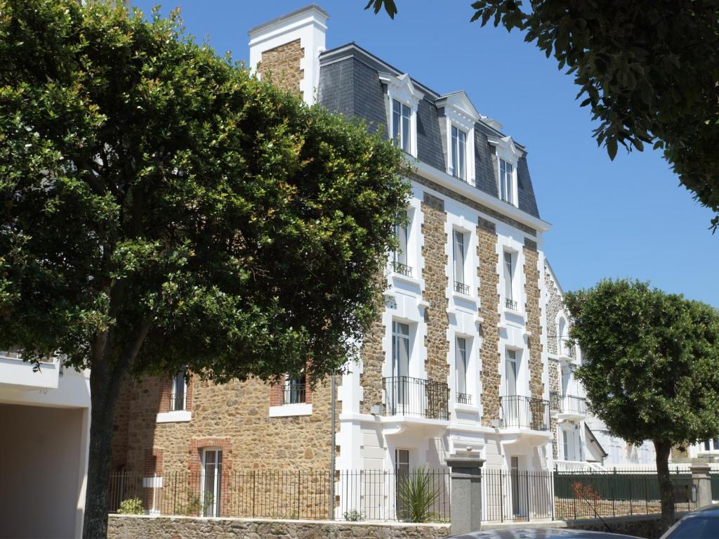 un bâtiment en briques avec un arbre devant lui dans l'établissement Villa des Thermes, à Saint-Malo