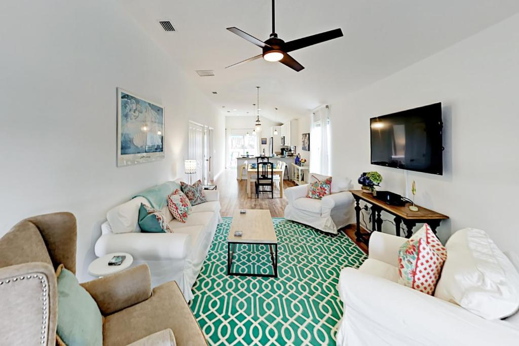 un soggiorno con mobili bianchi e ventilatore a soffitto di Walk to Beach with Private Pool, Balconies & Huge Lawn Blocks to Dining a Butler Beach
