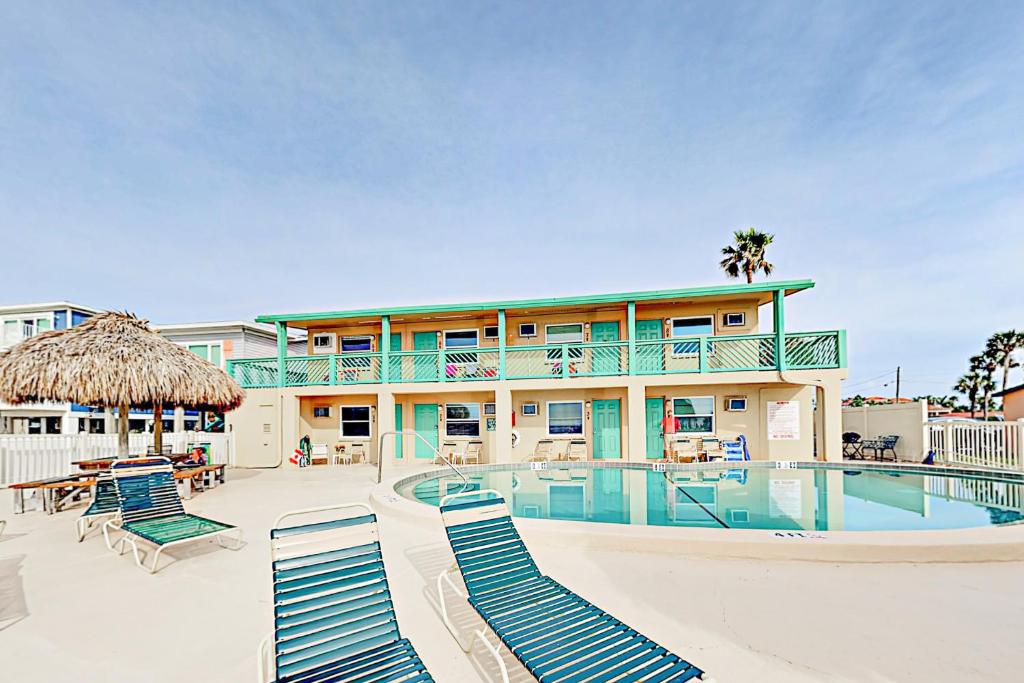 ośrodek z basenem, krzesłami i budynkiem w obiekcie Breezy Belleair 5E w mieście Clearwater Beach