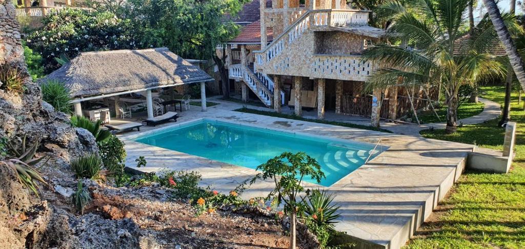 a swimming pool in front of a house at Marijani Holiday Resort in Watamu