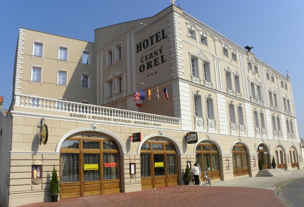 ein großes Gebäude mit einem Hotel neben einer Straße in der Unterkunft Hotel Černý Orel Žatec in Žatec