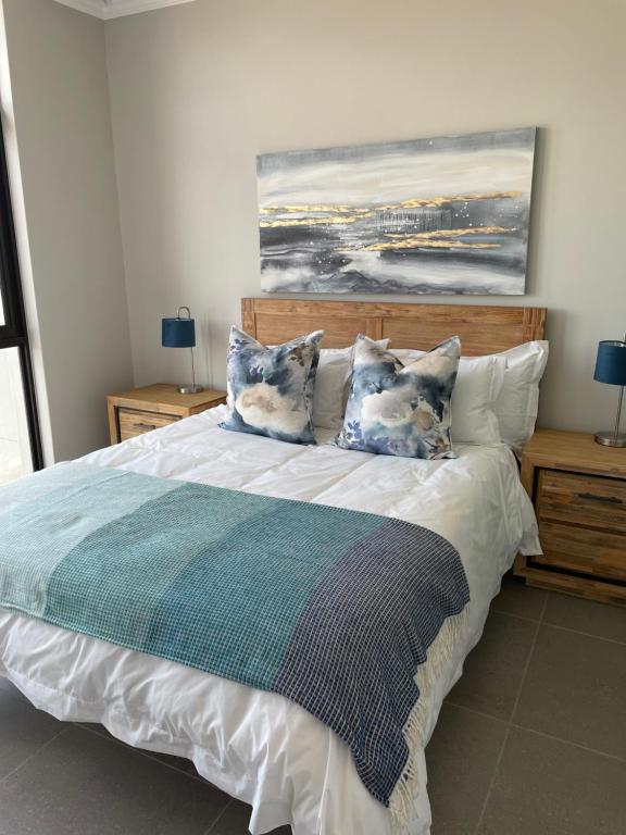 una camera da letto con un grande letto con cuscini di Flat 14 Block 6 Bellamare a Port Elizabeth