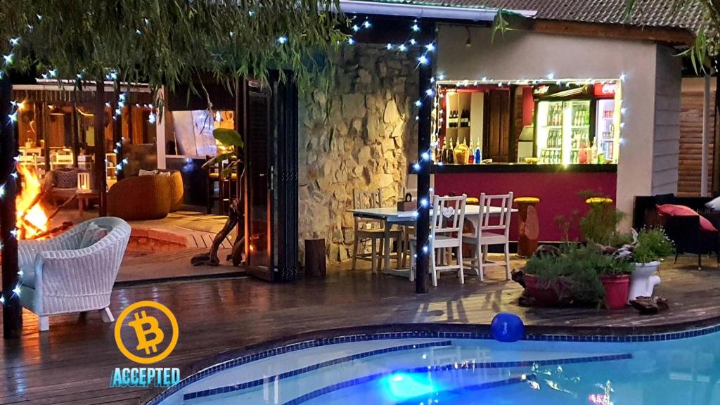 a pool in front of a restaurant with a bar at MALI Boutique Lodge & Tube 'n Axe Budget Accommodation in Stormsrivier
