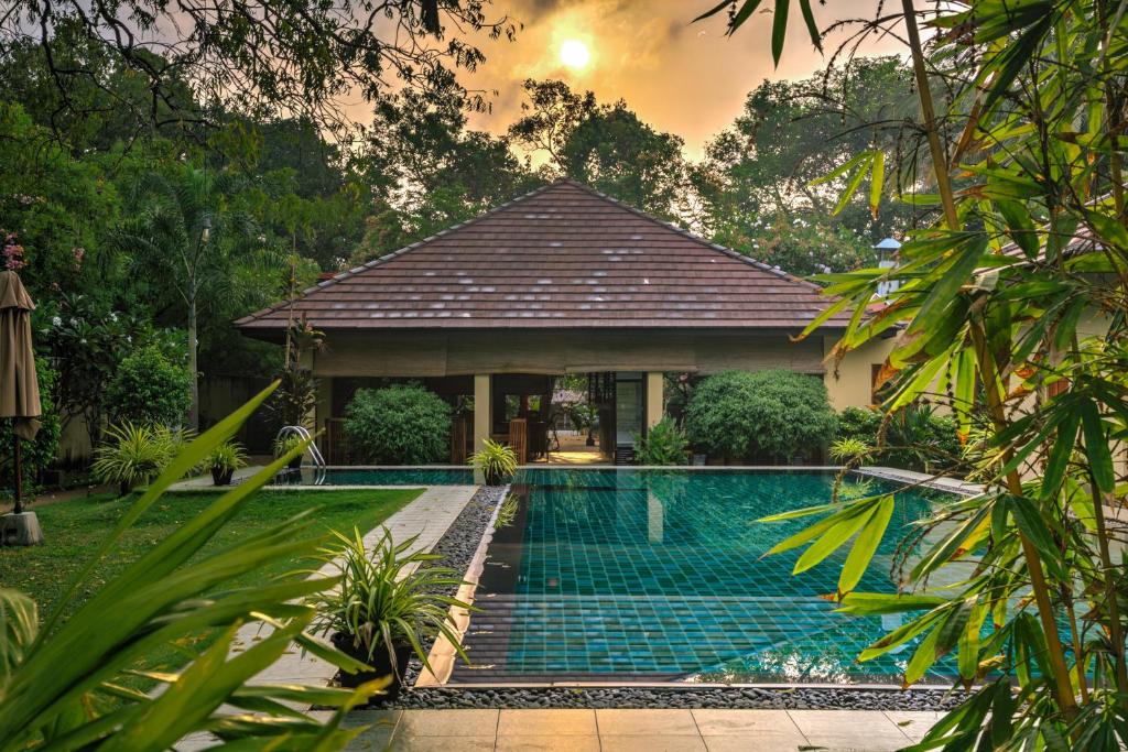 a villa with a swimming pool in front of a house at The Spice Trail in Arugam Bay