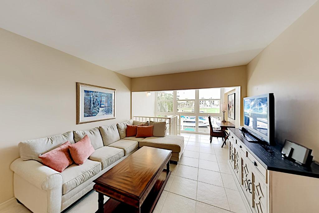 a living room with a couch and a tv at BeauMer 102B in Naples