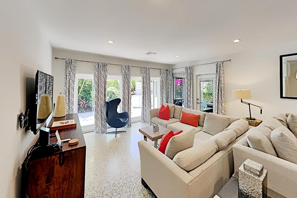 a living room with a white couch and red pillows at Designer Delight in Fort Lauderdale