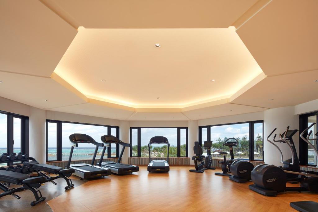 a gym with a row of treadmills and exercise bikes at Sheraton Okinawa Sunmarina Resort in Onna