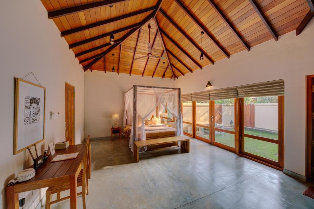 a room with a bedroom with a bed with a window at The Spice Trail in Arugam Bay
