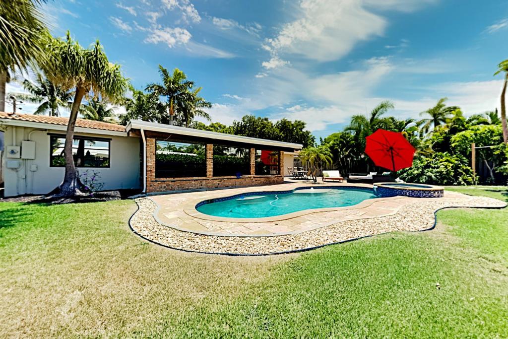 a backyard with a swimming pool and a house at Alfresco Beach Getaway in Pompano Beach