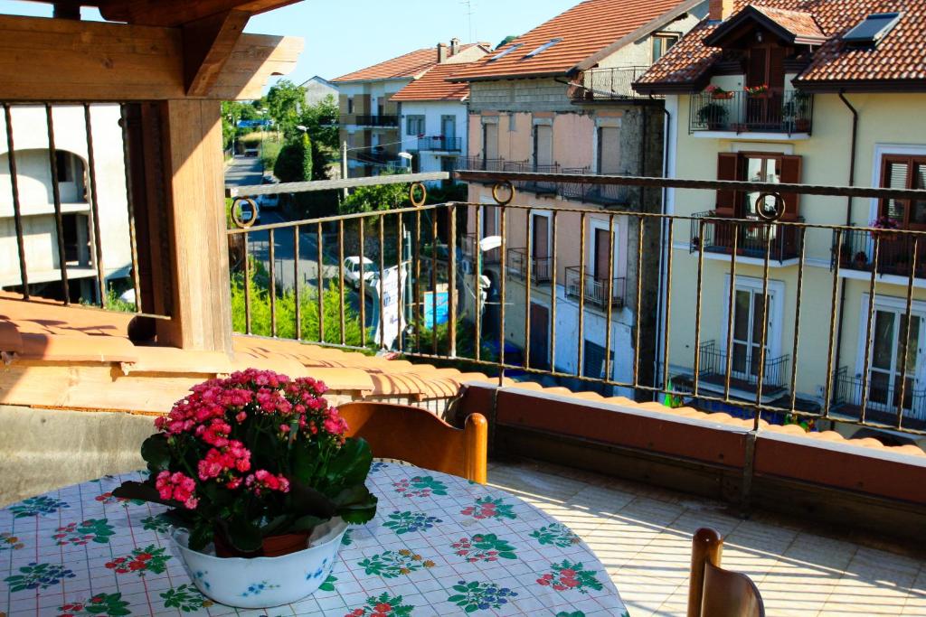 einen Tisch mit einer Blumenvase auf dem Balkon in der Unterkunft Casa Vacanze San Lorenzo in Agerola