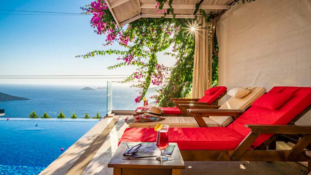 カルカンにあるEco Villa Mimozaのリビングルーム(赤いソファ付)が備わり、海の景色を望めます。