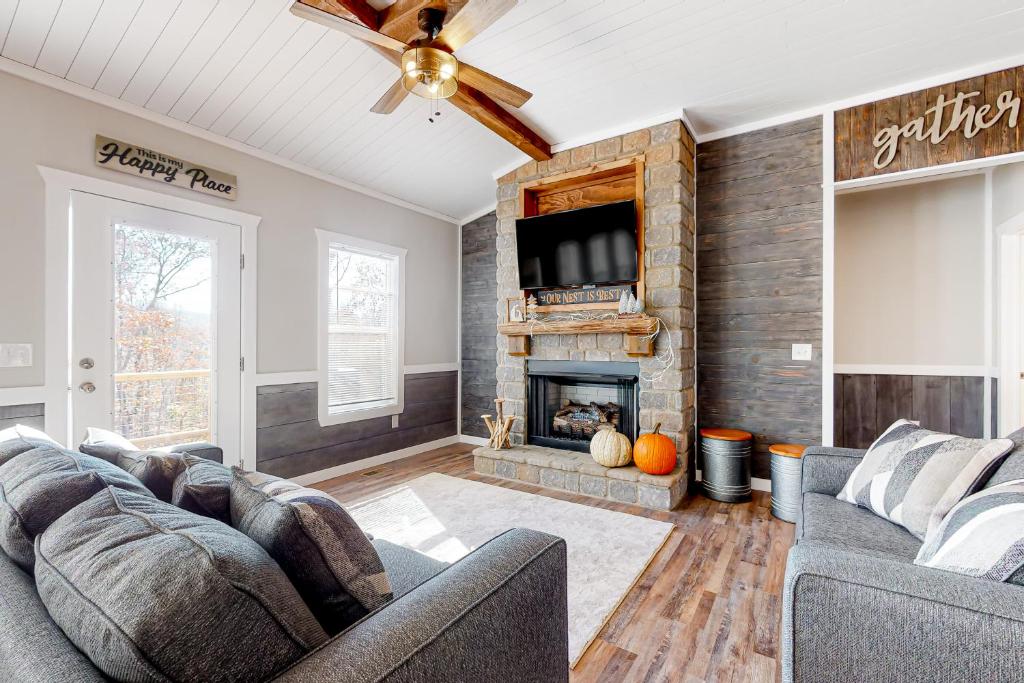 a living room with two couches and a fireplace at Rustic Mountain Cabin in Ellijay