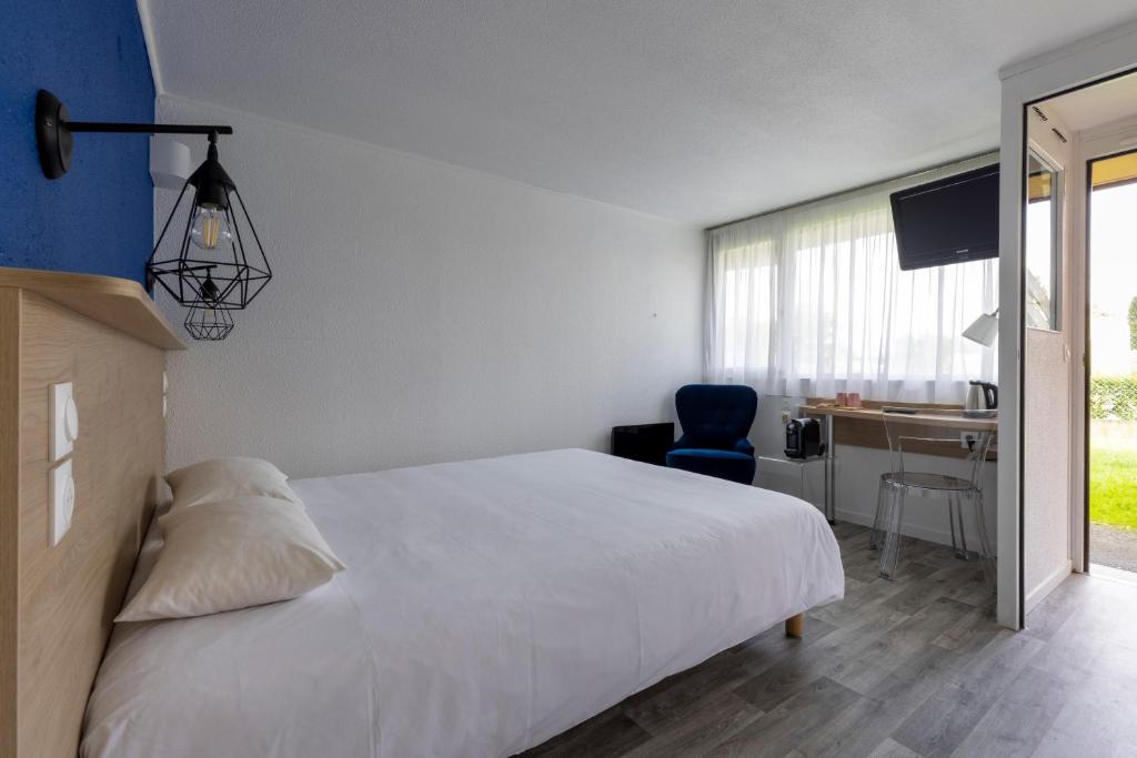 a bedroom with a bed and a desk and a chair at Le 2 By Hotel Akena - La Ferté Bernard in La Ferté-Bernard