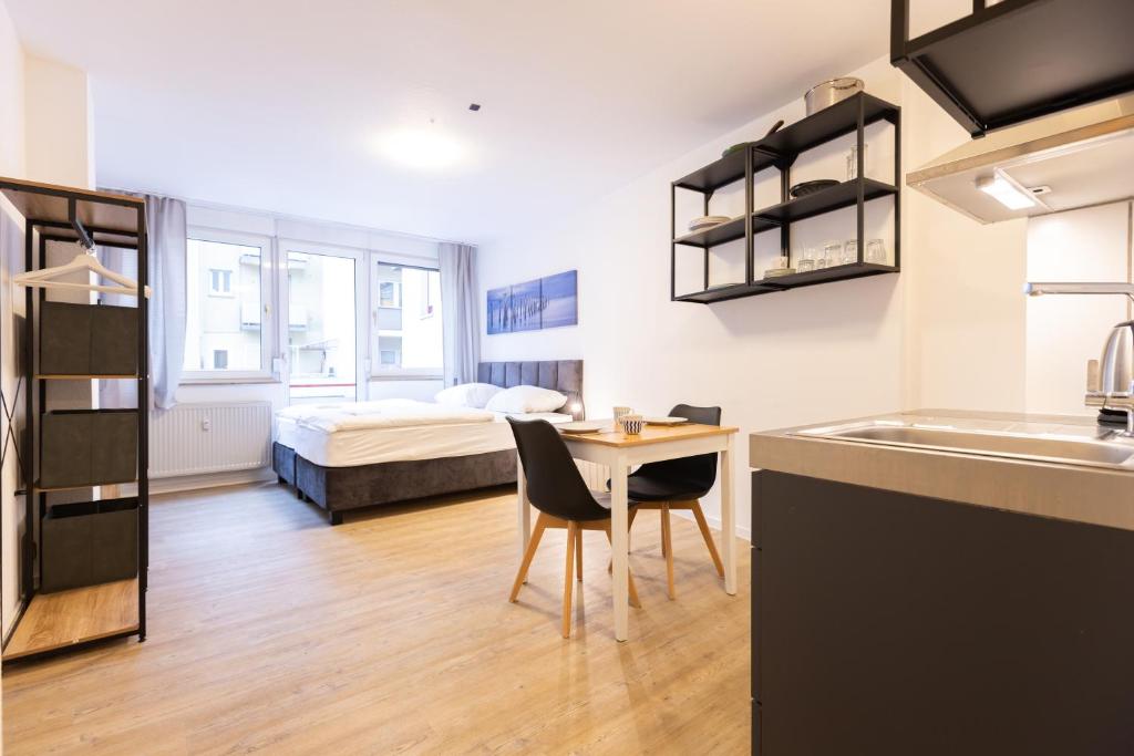 eine Küche mit einem Tisch und einem Bett in einem Zimmer in der Unterkunft Modernes Apartment in der Innenstadt in Würzburg