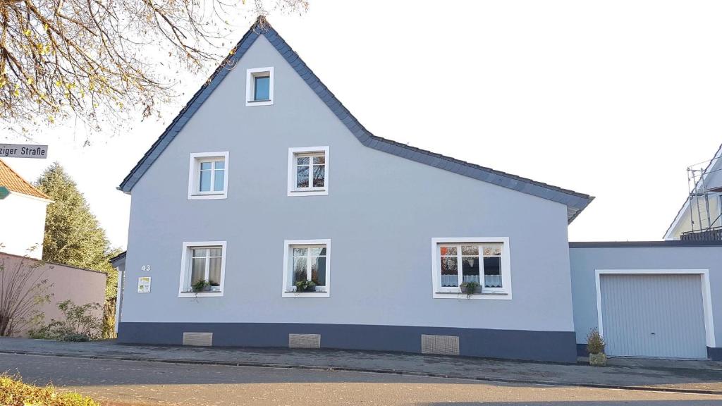 ein weißes Haus mit blauem Dach in der Unterkunft Ferienwohnung Sommer in Sankt Wendel