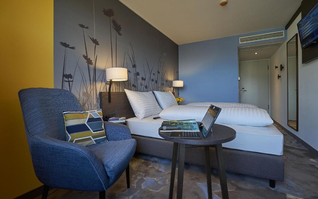 Schlafzimmer mit einem Bett und einem Laptop auf einem Tisch in der Unterkunft Hwest Hotel in Hall in Tirol