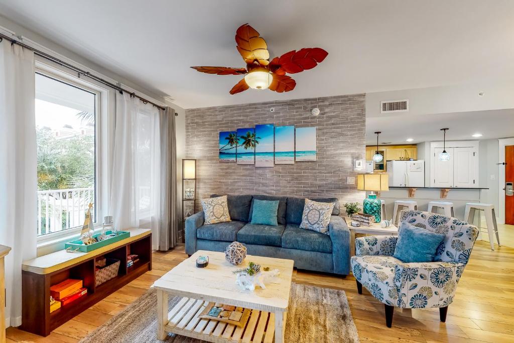 a living room with a blue couch and a table at Beauty by the Bay in Destin