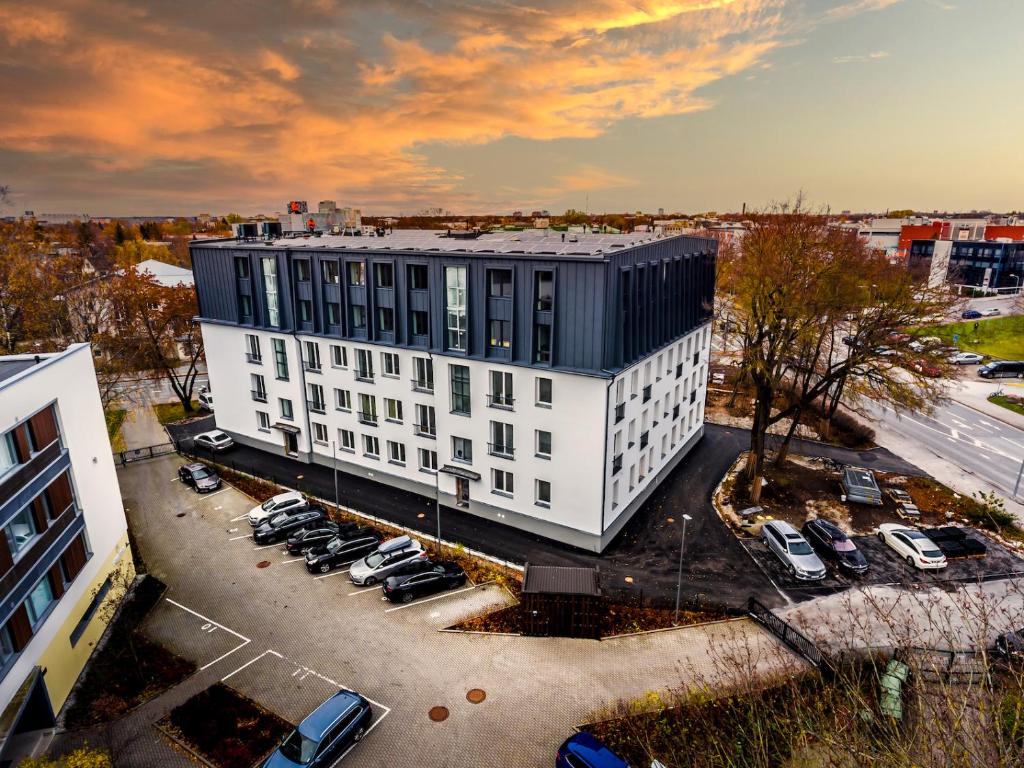 a large white building with cars parked in a parking lot at MyApartments Kotka in Tallinn