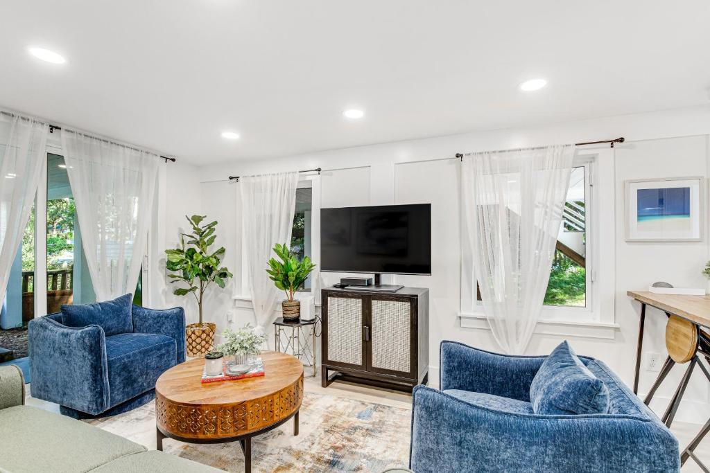 富麗海灘的住宿－Folly's Hideaway A，客厅配有蓝色椅子和电视