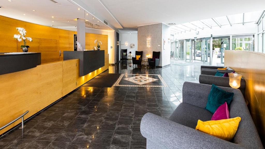 a lobby with a couch and chairs in a building at Hotel Schützenhof in Eitorf