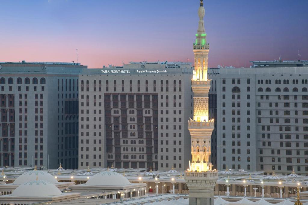 a large building with a clock tower in front of it at Taiba Front Hotel in Al Madinah