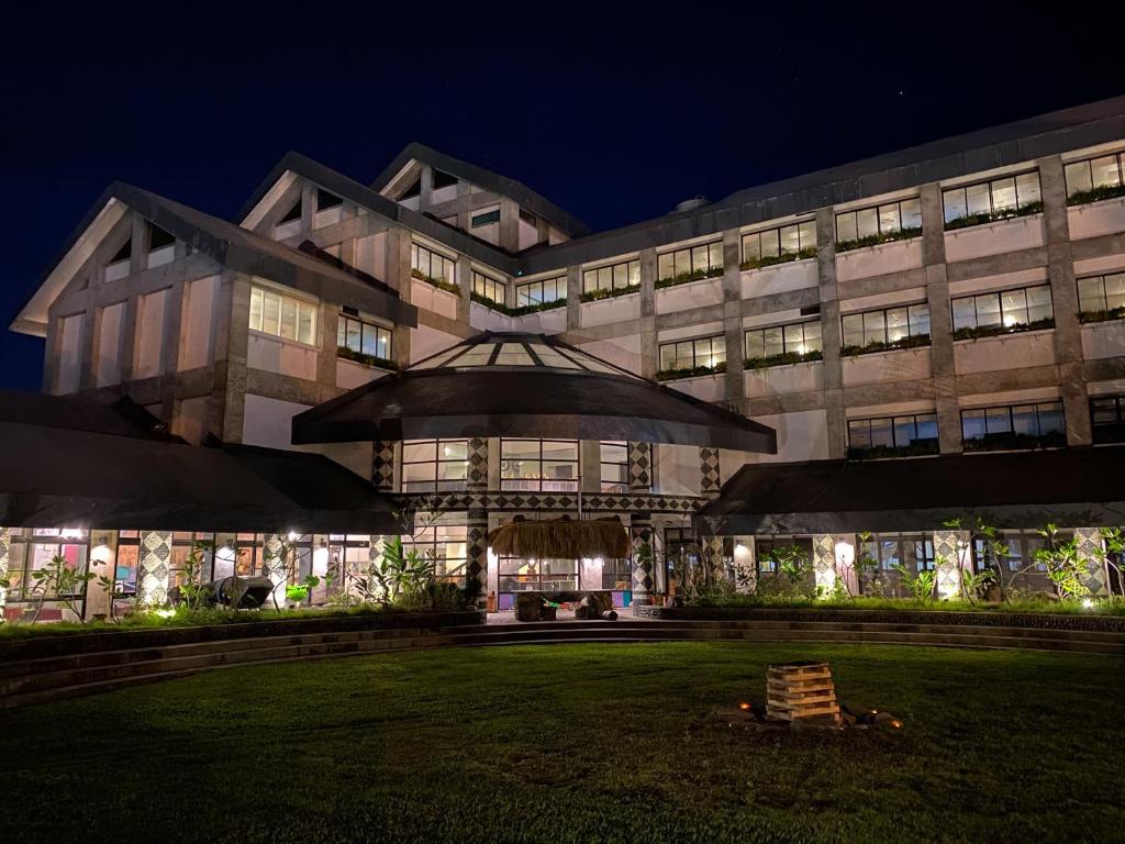 台東市的住宿－伊塔原旅臺東縣原住民文化會館 ，一座大型建筑,在晚上前方有一个草坪