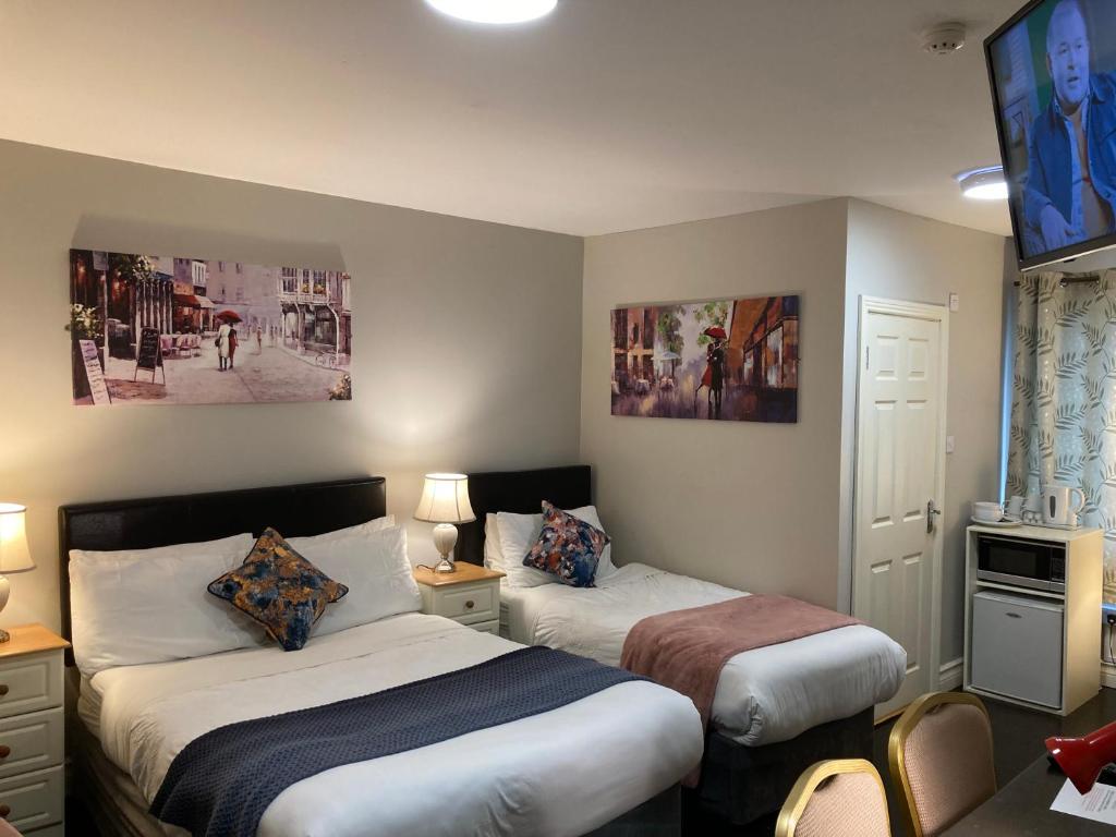 a hotel room with two beds and a tv at Leitrim Lodge in Carrick on Shannon