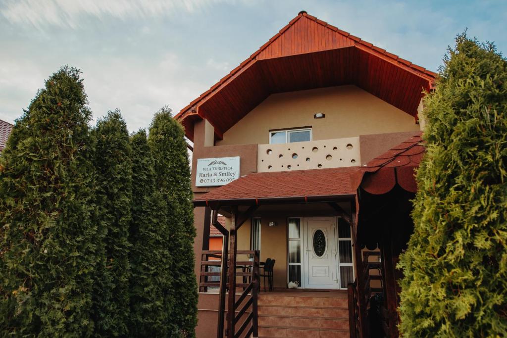 dom z czerwonym dachem i drzewami w obiekcie Pensiunea Karla w mieście Turda
