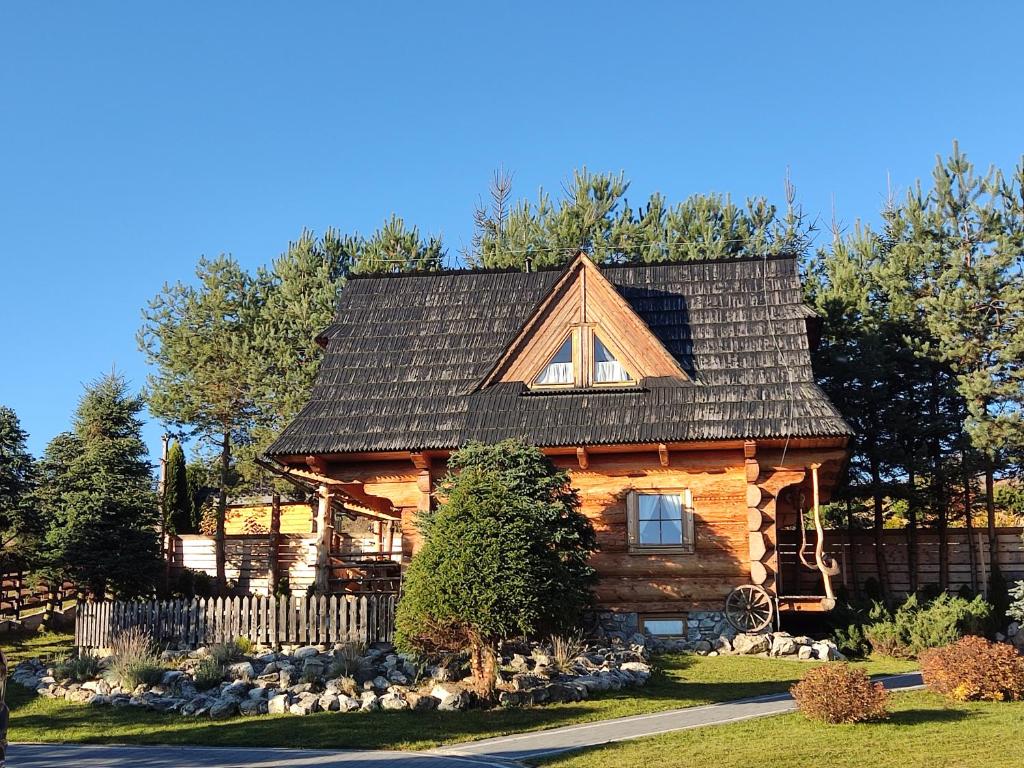 a log cabin with a gambrel roof at Domki Szwajnosówka in Witów