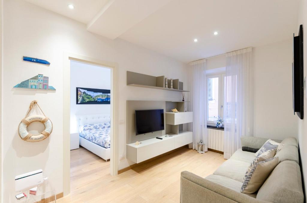 ein weißes Wohnzimmer mit einem Sofa und einem Spiegel in der Unterkunft Appartamento di design in Rapallo