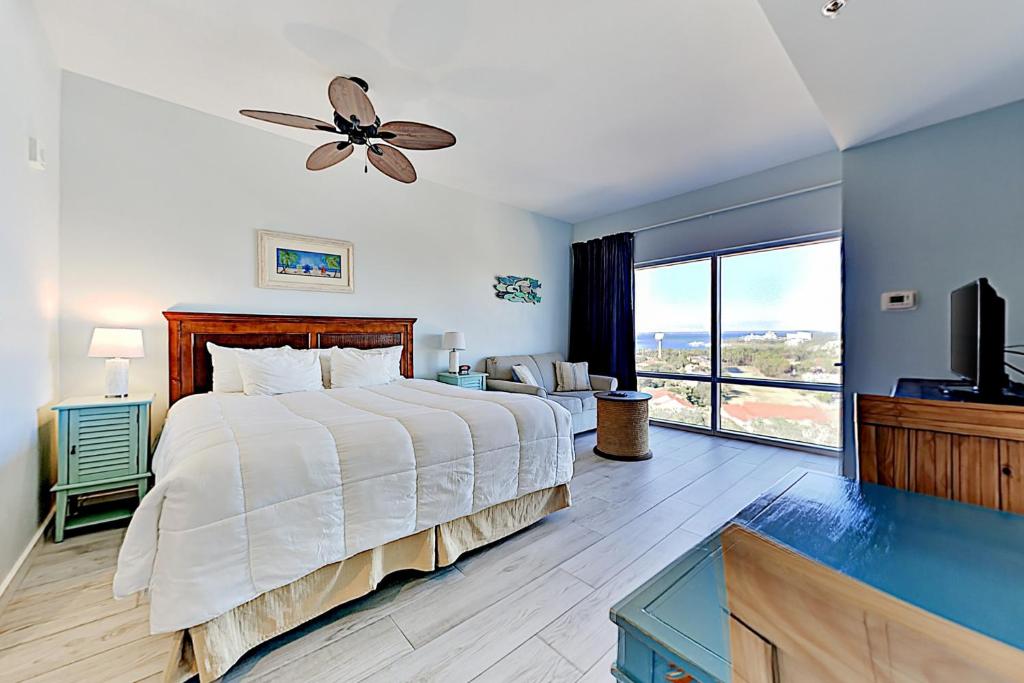 a bedroom with a large bed with a ceiling fan at Luau Condos V in Destin