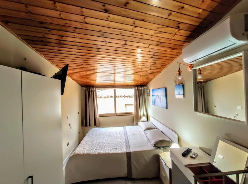 1 dormitorio con cama, escritorio y ventana en Nel Centro Storico A Casitta Da Mola, en Castelmola
