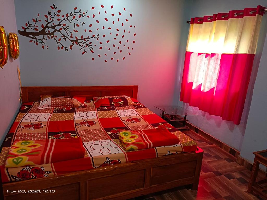 Un dormitorio con una cama con sábanas rojas y una ventana en Gharat Cottage en Alibaug