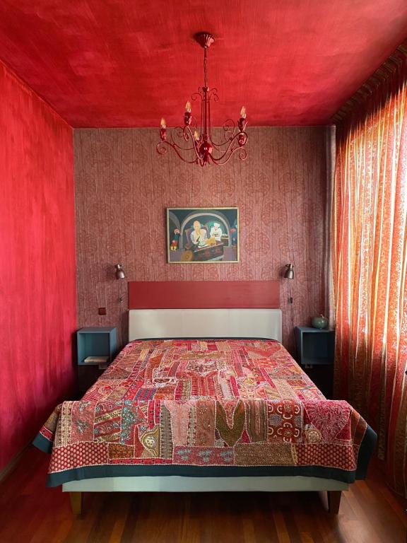 ein rotes Schlafzimmer mit einem Bett mit roter Decke in der Unterkunft Rävala Boulevard Apartment in Tallinn