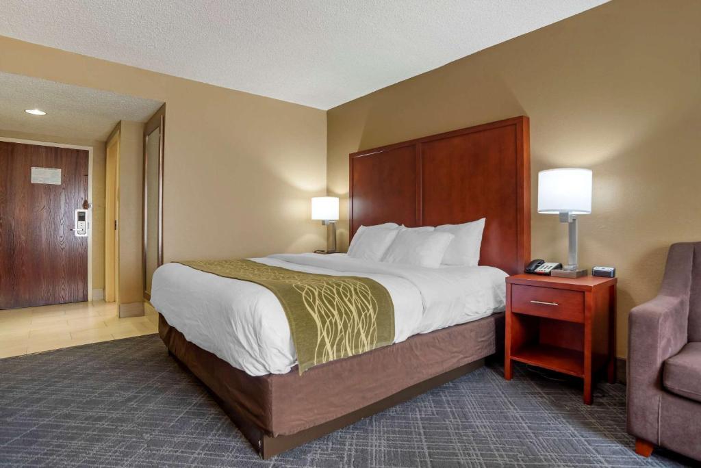 een hotelkamer met een groot bed en een stoel bij Comfort Inn University Area in Baton Rouge
