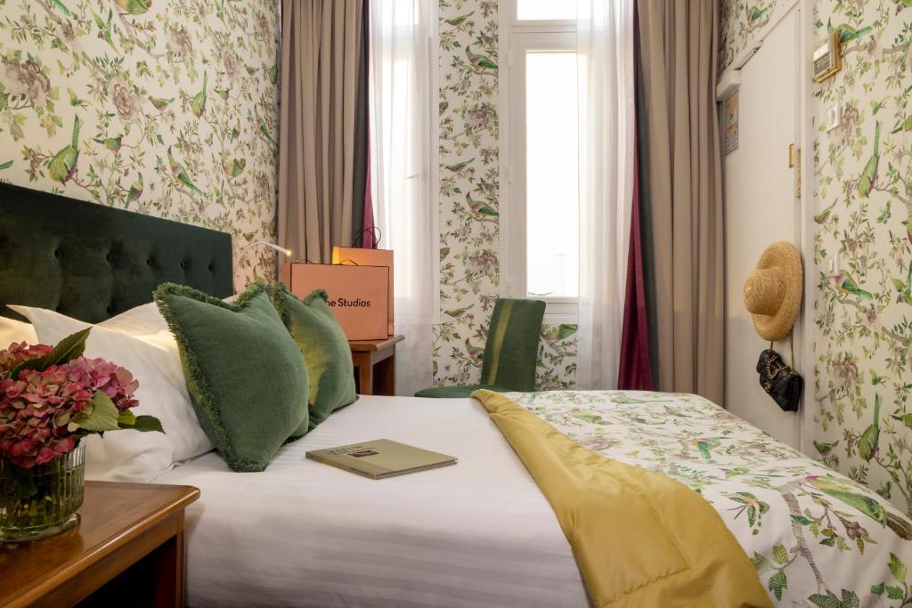 ein Hotelzimmer mit einem Bett mit einem Buch darauf in der Unterkunft Hôtel Le Regent Paris in Paris