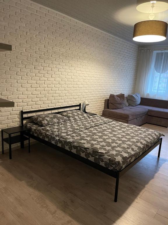 a bed in a room with a brick wall at 073 Уютная квартира ЖК «Софиевская Слободка» in Vyshneve