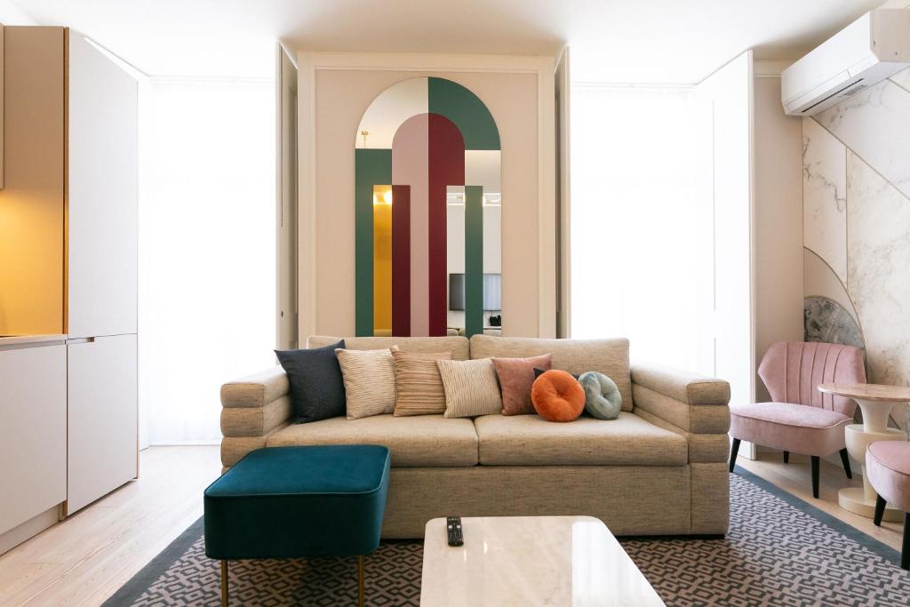 a living room with a couch and a colorful wall at The Lift Apartments by RIDAN Hotels in Lisbon