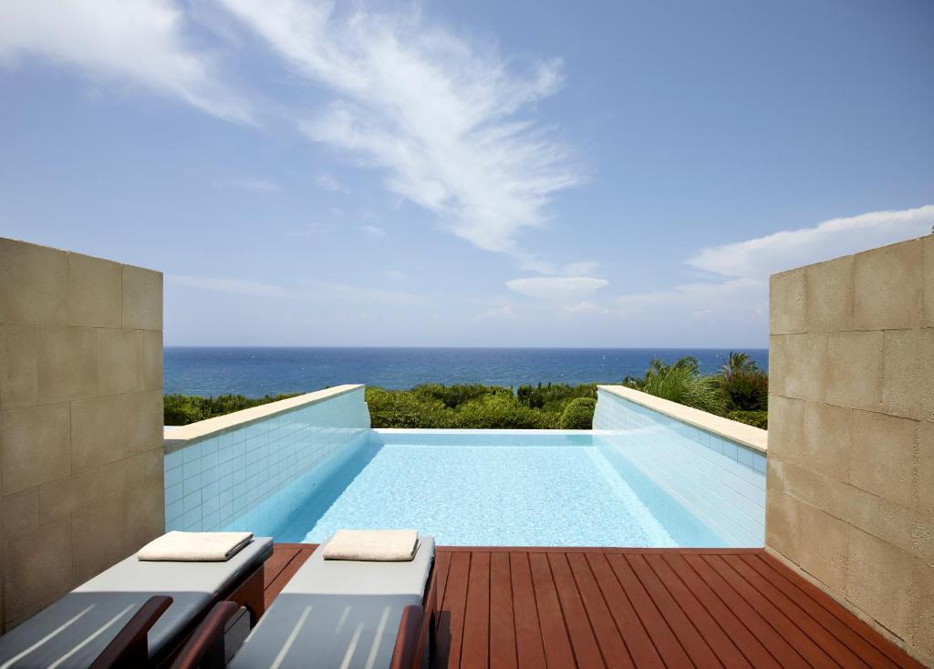 a swimming pool with a view of the ocean at Elite Suites by Rhodes Bay in Ixia