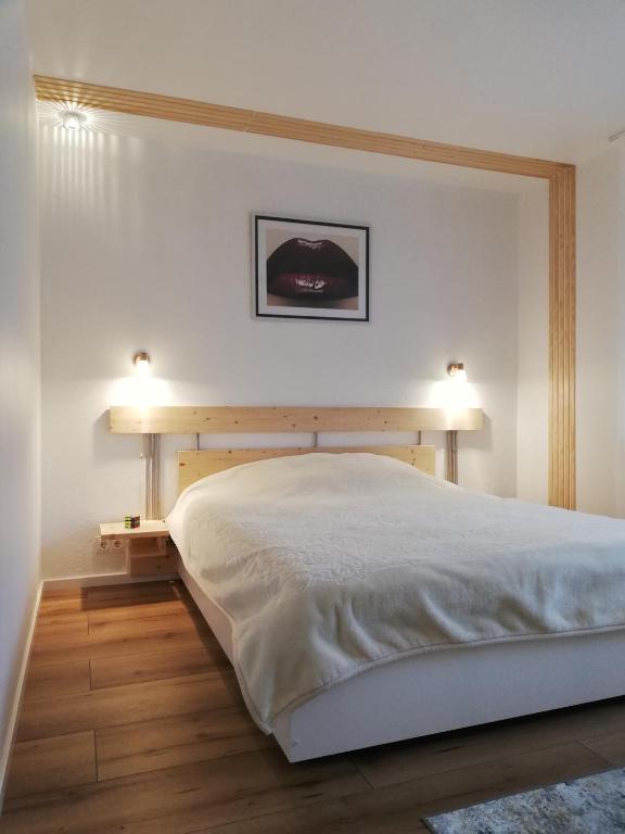 a bedroom with a bed with two lamps on it at Poilsis Jums in Nida