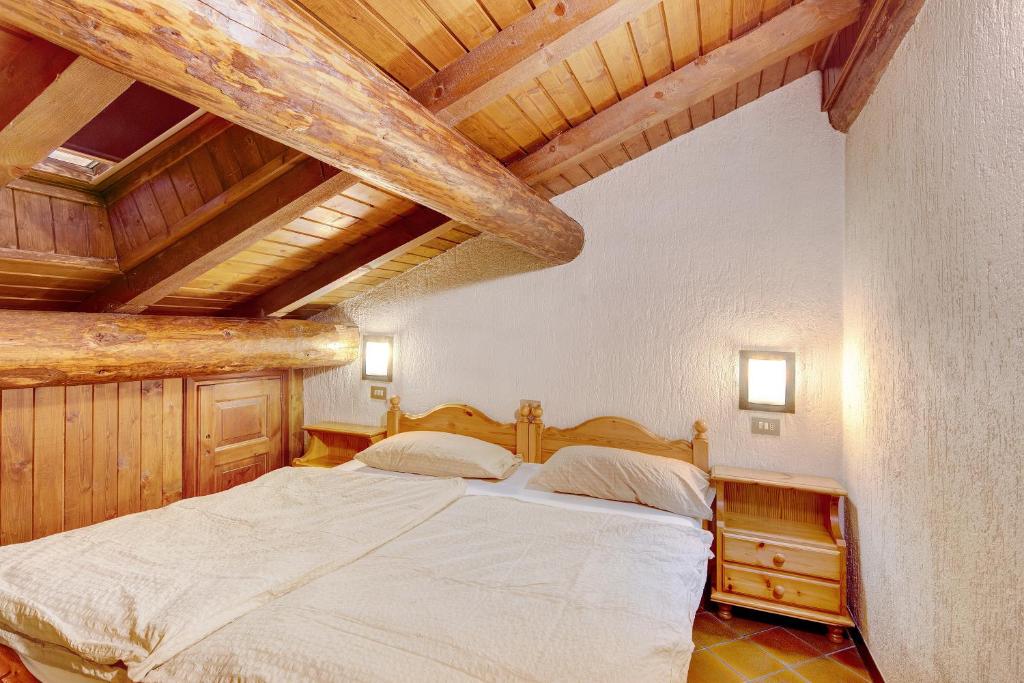 Łóżko lub łóżka w pokoju w obiekcie Chalet Meridiana Appartamento 11