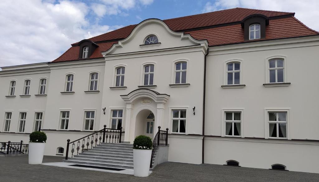 un gran edificio blanco con techo rojo en Adler, en Swarzędz