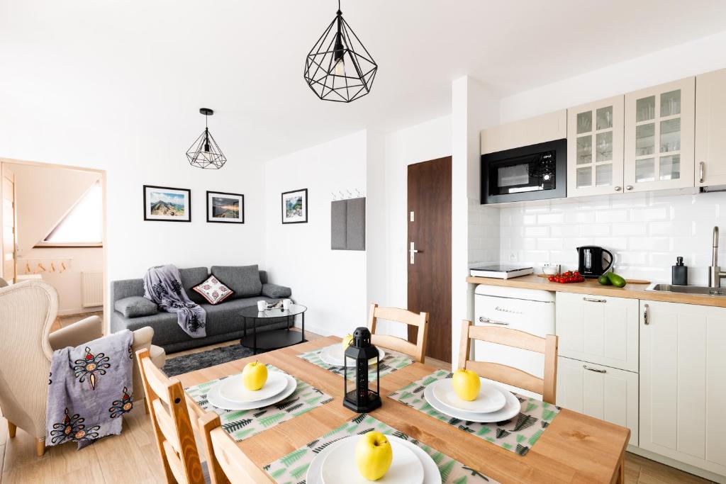 cocina y sala de estar con mesa y sillas. en Dom Pod Gubałówką - Zakopane Apartamenty, en Zakopane