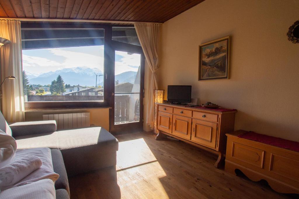 ein Wohnzimmer mit einem Sofa und einem großen Fenster in der Unterkunft Apartment Schmid - Steinbock Lodges in Maishofen