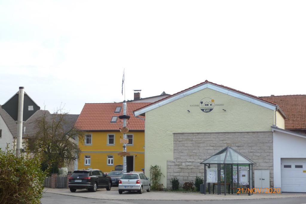 a yellow and white building with cars parked in front of it at Ferienwohnungen Kay in Kirchaich